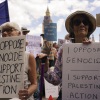 Demonstrators hold placards during a protest in support of the Palestinian People in Gaza, in Parliament Square, in London, Saturday, Aug. 9, 2025.