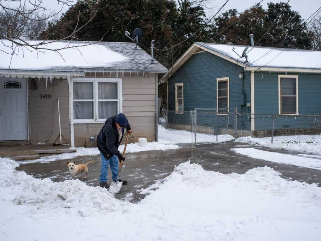 A Waco, Texas, resident clears snow from his driveway alongside his dog on February 17, 2021 as severe winter weather conditions over the last few days has forced road closures and power outages over the state. - Millions of people were still without power on February 17 in Texas, the oil and gas capital of the United States, and facing water shortages as an unusual winter storm pummeled the southeastern part of country. The National Weather Service (NWS) issued a winter storm warning for a swathe of the country ranging from east Texas to the East Coast state of Maryland. (Photo by Matthew Busch / AFP) (Photo by MATTHEW BUSCH/AFP via Getty Images)