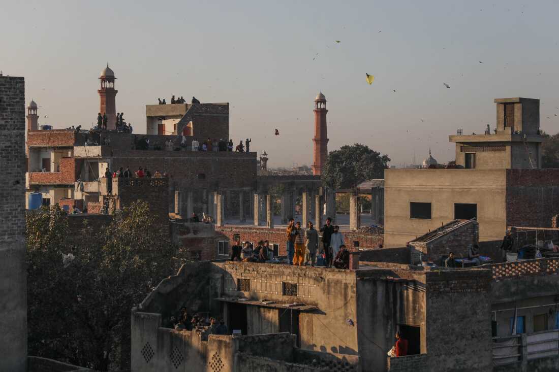 People flying kites stand on rooftops in Lahore's Old City during Basant on Feb. 7, 2026, in Lahore, Pakistan.