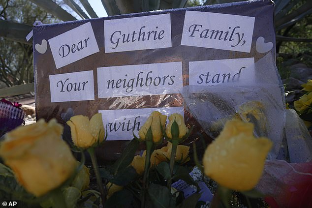 Yellow flowers and signs remain at a vigil outside of Nancy Guthrie's home on Saturday, Feb. 14, 2026 in Tucson, Ariz.  (AP Photo/Ty O'Neil)