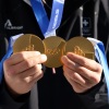 Triple Olympic Gold medalist Franjo von Allmen of Team Switzerland poses for a photo with his medals at the team hotel on Feb. 12 in Bormio, Italy.