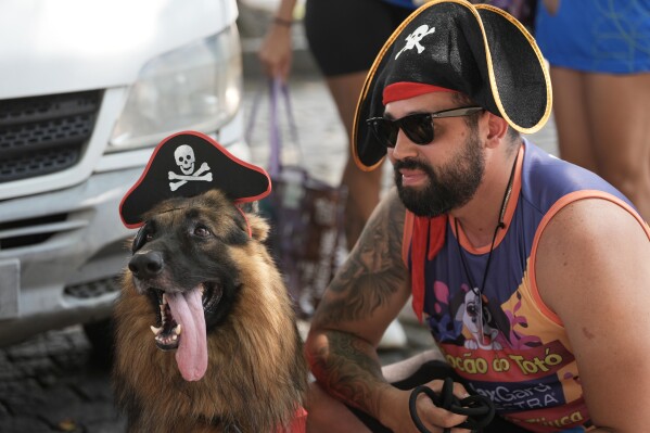 A dog and its owner wear pirate costume during the "Blocao" Carnival dog parade in Rio de Janeiro, Saturday, Feb. 14, 2026. (AP Photo/Silvia Izquierdo)