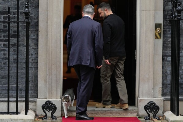 Britain's Prime Minister Keir Starmer welcomes Ukrainian President Volodymyr Zelenskyy to 10 Downing Street as Larry the cat, Chief Mouser to the Cabinet Office, steps out in London, Thursday, Oct. 10, 2024. (AP Photo/Alastair Grant, File)
