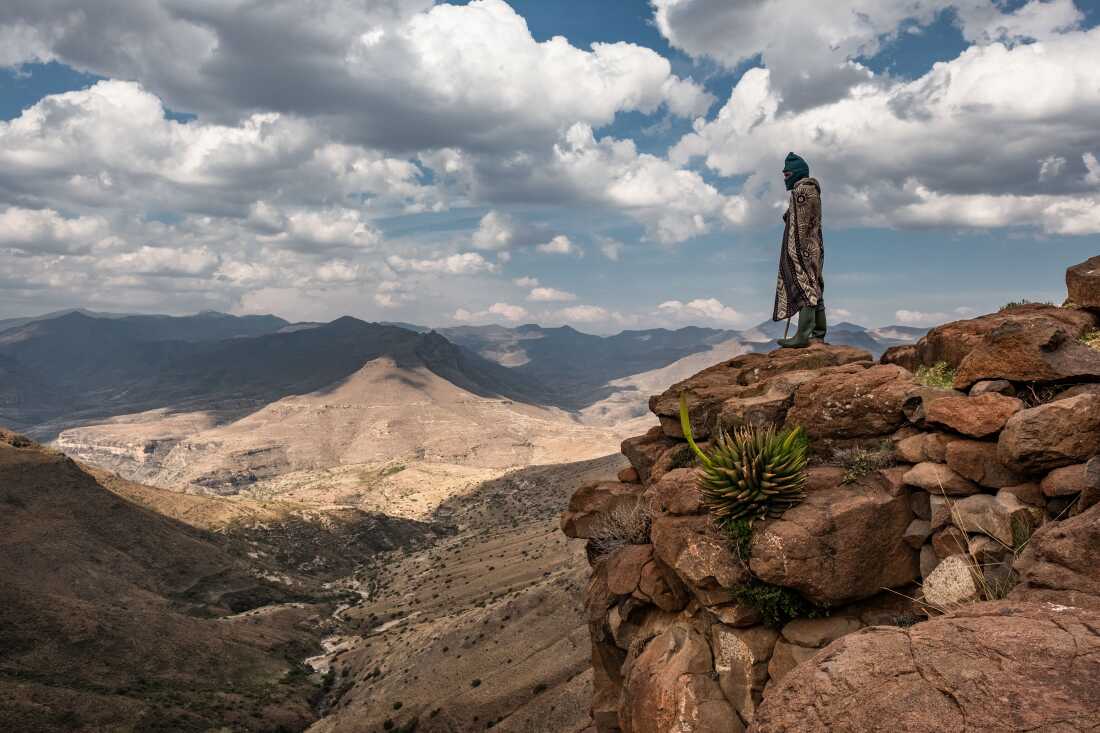 Shepherd Bernard Nphukeng looks out from a cliff on the edge of the isolated village of Ha Pheulane, Lesotho, after having a tooth removed during a visit by dental therapist Senate Maklhoali of the Lesotho Flying Doctor Services.