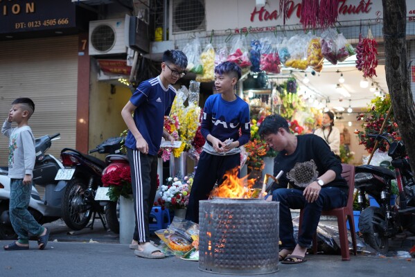 People burn joss paper money as offering to ancestors ahead of the Lunar New Year of the Horse in Hanoi, Vietnam, Sunday, Feb 15, 2026. (AP Photo/Hau Dinh)