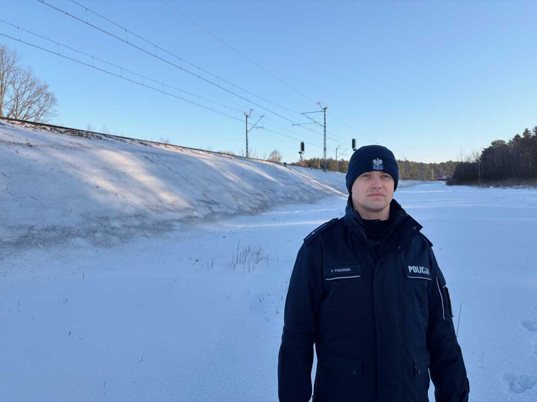 Police officer Piotr Porkoski stands in front of the portion of the Warsaw-Ukraine train line where Polish authorities say two Ukrainian perpetrators hired by Russia’s government used explosives to attempt to blow up the track last November. A train conductor noticed the warped rail and called the police.