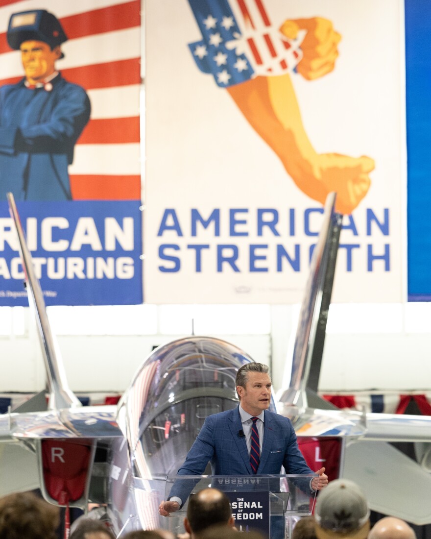 U.S. Secretary of War Pete Hegseth speaks to a crowd of Boeing employees while banners reading “American Manufacturing — American Strength” hang in the background. The speaking event was part of Hegseth’s “Arsenal of Freedom” tour.