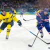 Sweden's Mika Zibanejad (93) and United States' JT Miller (10) chase the puck during the third period of a men's ice hockey quarterfinal game at the 2026 Winter Olympics, in Milan, Italy, Wednesday, Feb. 18, 2026. (AP Photo/Hassan Ammar)