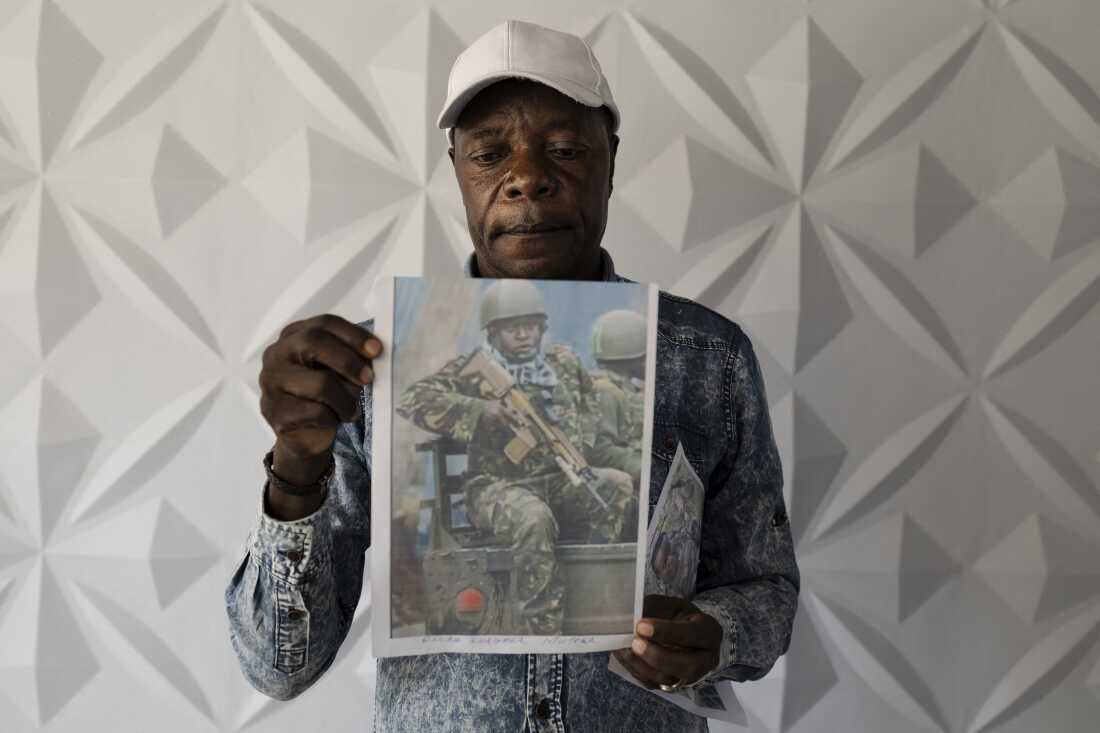 Charles Ojiambo Mutoka, 72, stands with portraits of his son Oscar, who was killed in Aug. 2025, during a press conference in Nairobi on Jan. 27, 2026, where relatives of conscripts called on the government to urgently repatriate their loved ones.