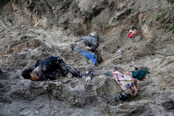 EDS NOTE: GRAPHIC CONTENT - FILE - The bodies of people lie half-buried in a mass grave in Motyzhyn close to Kyiv, Ukraine, Monday, April 4, 2022. (AP Photo/Efrem Lukatsky)