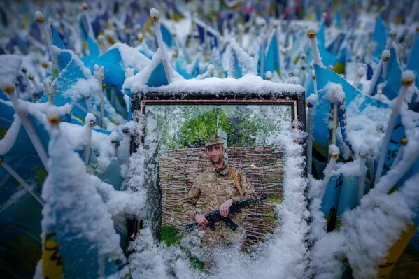 Snow covers the photograph of a fallen Ukrainian serviceman in downtown Kyiv, Ukraine, Tuesday, March 12, 2024. (AP Photo/Vadim Ghirda, File)
