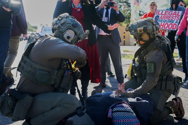 U.S. Rep. Adelita Grijalva, standing, talks to Homeland Security Investigation agents as they arrest a protester during a targeted operation in Tucson, Ariz., Friday, Dec. 5, 2025. (Mamta Popat /Arizona Daily Star via AP)
