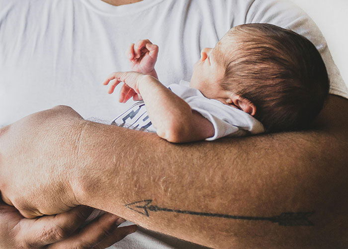 Father holding newborn baby gently in his arms, highlighting protective and caring bond with autistic child. Father holding newborn baby gently in his arms, highlighting protective and caring bond with autistic child.