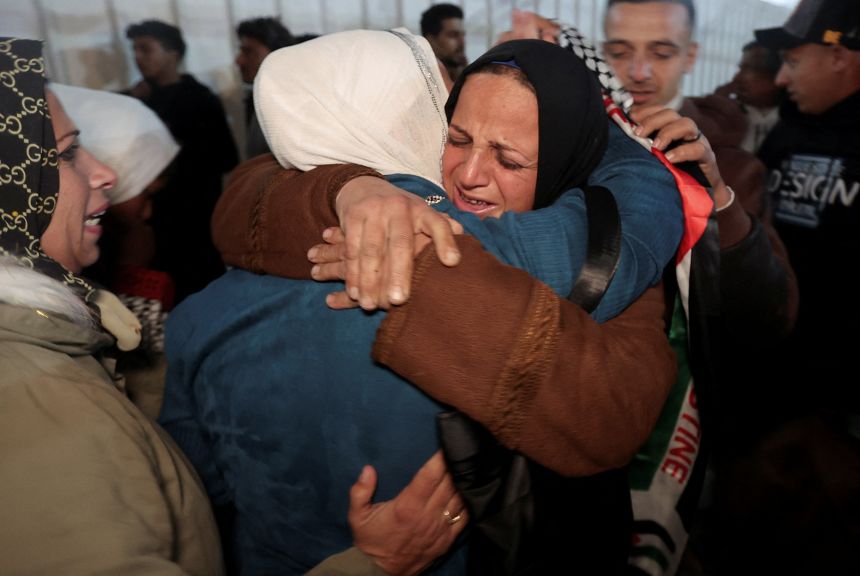 Palestinians coming from the Rafah crossing embrace as they arrive at Nasser Hospital in Khan Younis, Gaza, on Thursday.