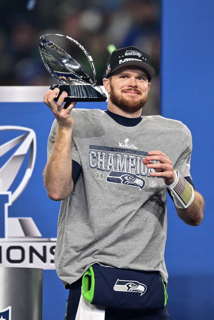 Sam Darnold #14 of the Seattle Seahawks celebrates with the George Halas Trophy after defeating the Los Angeles Rams 31-27 in the NFC Championship game at Lumen Field on January 25, 2026 in Seattle, Washington. 