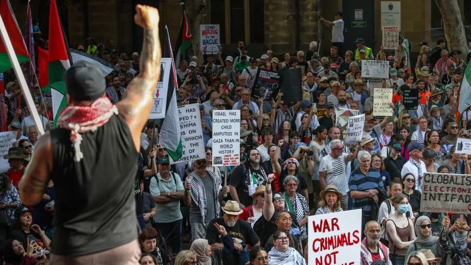People hold up placards during a protest against the visit of Israel's President Isaac Herzog in Sydney, Australia, on February 9, 2026. - Lisa Maree Williams/Getty Images