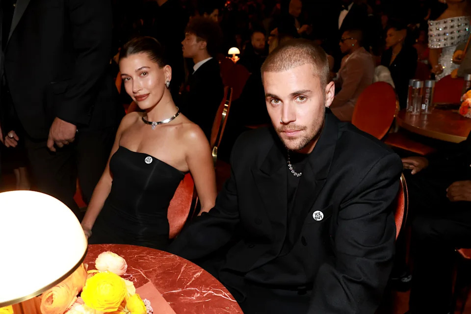 Hailey Bieber and Justin Bieber sit together inside the Grammys. He doesn't look thrilled with photographers, but he was happy with his wife.