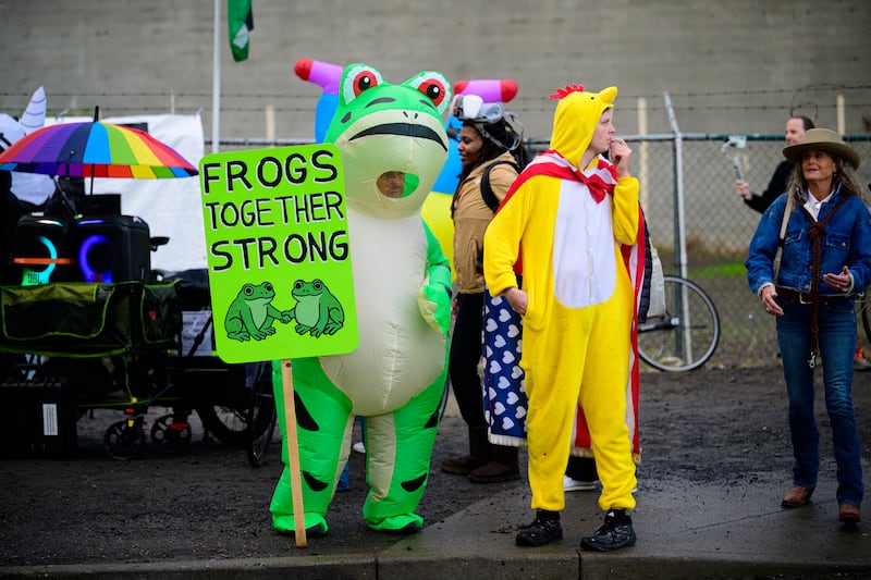 n anti-I.C.E. protester in a frog costume holds a sign at the U.S. Immigration and Customs Enforcement building on October 12, 2025 in Portland, Oregon.