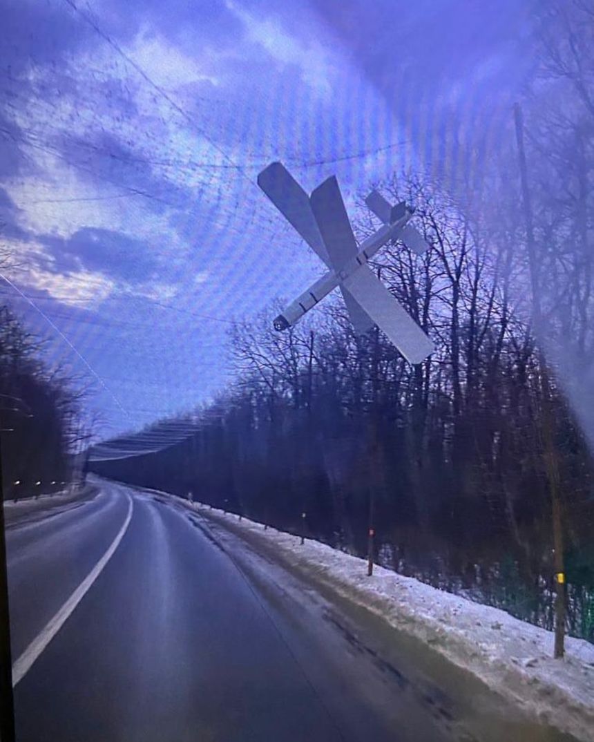 A Russian drone targeting a car relatively far from the front line is caught in a net covering the road.