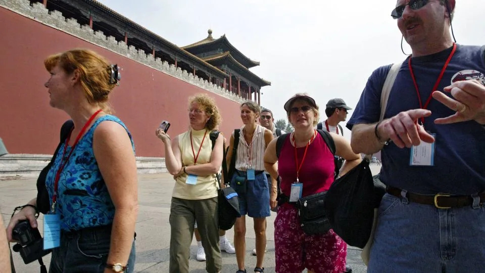 A group of American tourists from Minnesota wait for entry to the Forbidden City in Beijing, China, on 25 August 2003. - Mark Ralston/South China Morning Post/Getty Images