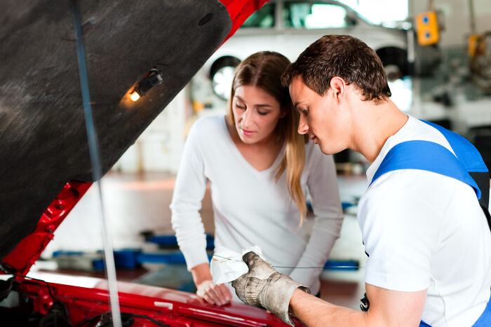 Woman and man checking car engine in a garage, illustrating daily worries versus peaceful bliss themes.