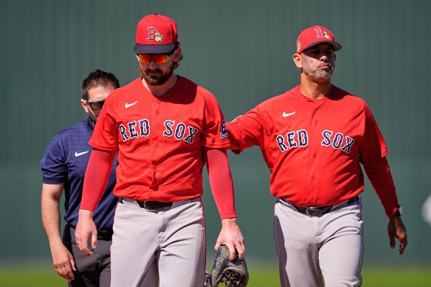 Red Sox manager Alex Cora (right) helps escort Brendan Rodgers off the field after the second baseman injured himself making a play in the fourth inning against the Twins. 
