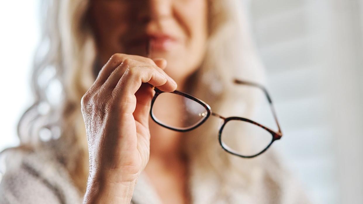 Woman holding eyeglasses