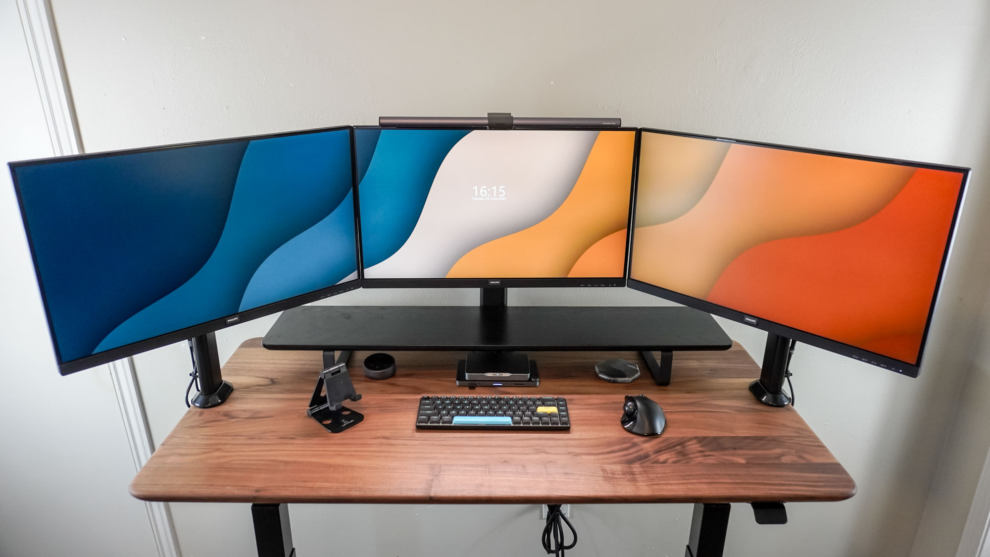 A triple monitor setup on a wooden desk