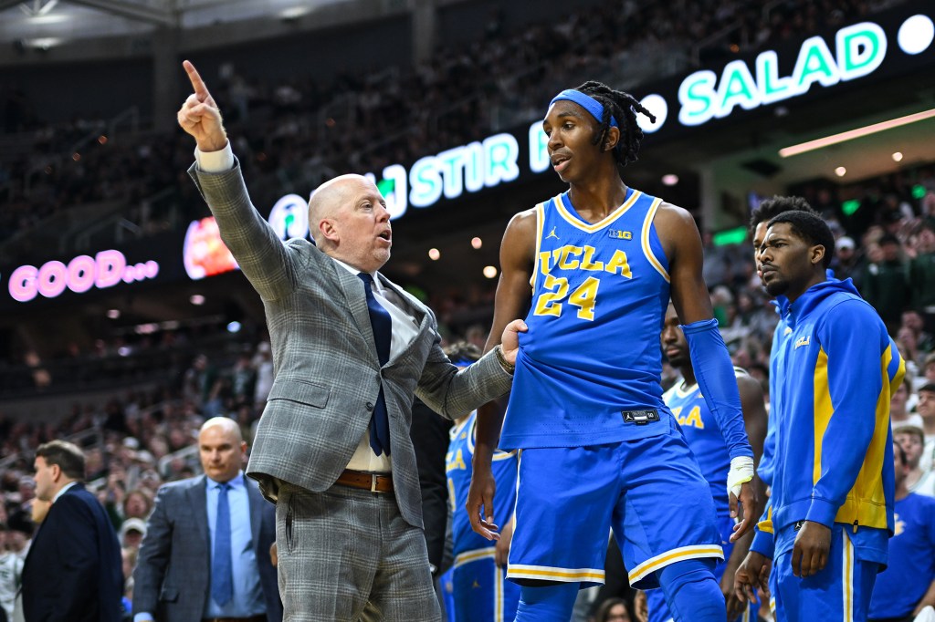 UCLA Bruins head coach Mick Cronin sending forward Steven Jamerson to the locker room during a basketball game.