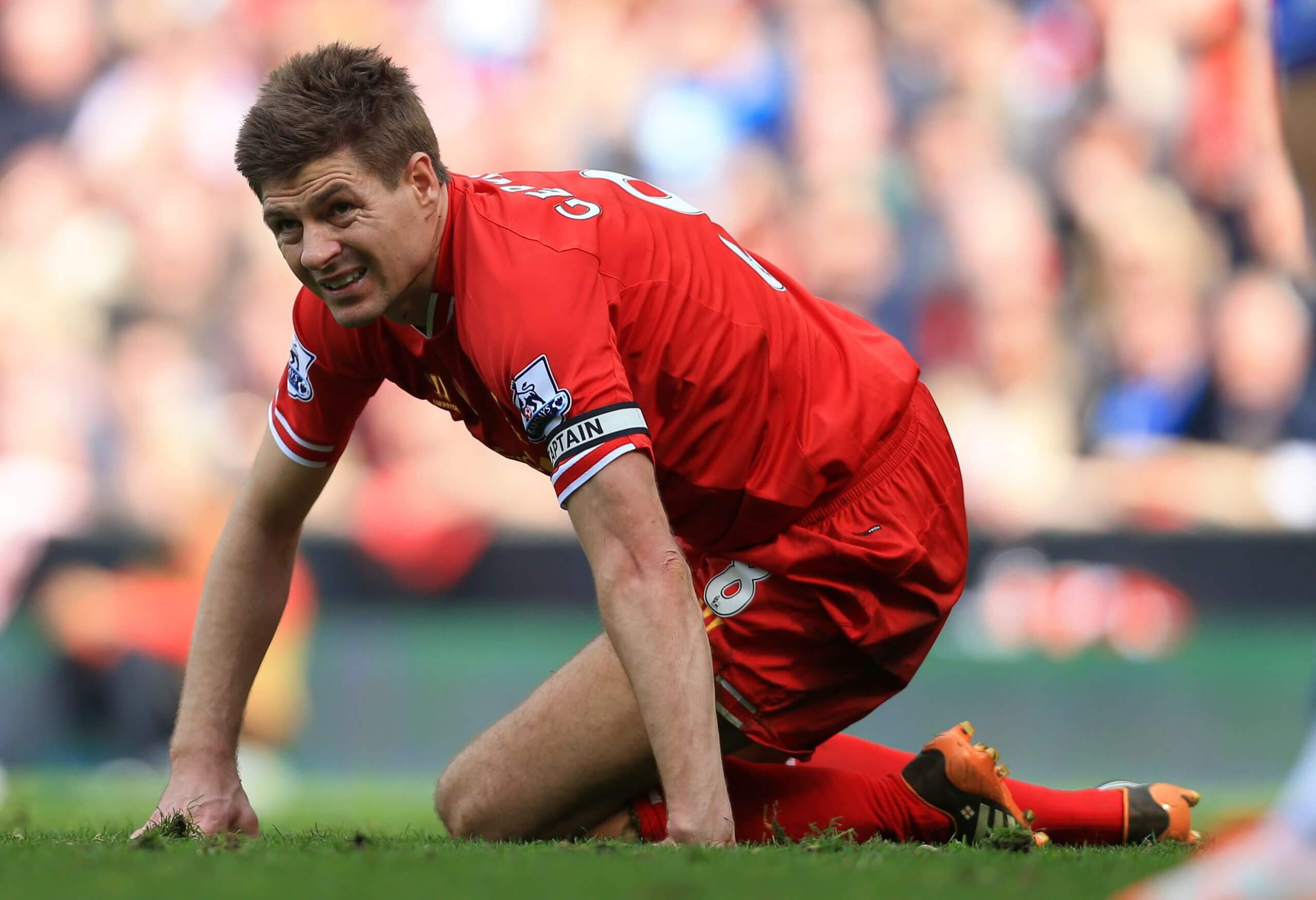 Steven Gerrard crouches on the floor after slipping