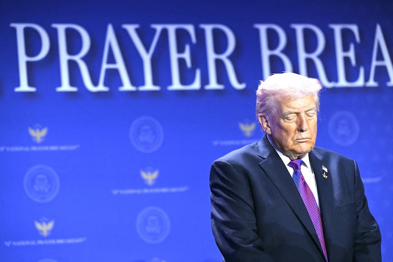 US President Donald Trump bows his head in prayer during the National Prayer Breakfast.
