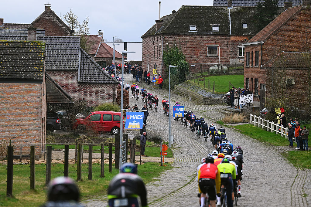 NIVONE, BELGIUM - FEBRUARY 28: A general view of the peloton passing through the Eikenberg cobblestones sector during the 21st Omloop Het Nieuwsblad 2026, Men&amp;apos;s Elite a 207.2km one day race from Ghent to Ninove / #UCIWT / on February 28, 2026 in Ninove, Belgium. (Photo by Tim de Waele/Getty Images)