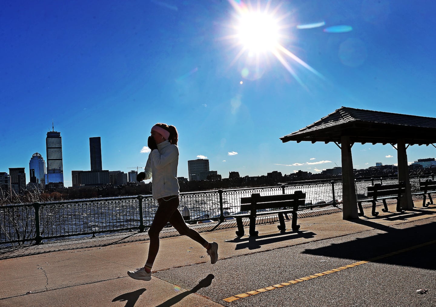 A jogger covers her face from the cold air while running on Memorial Drive along the Charles River in December. Exercise is important for helping lower blood sugar.