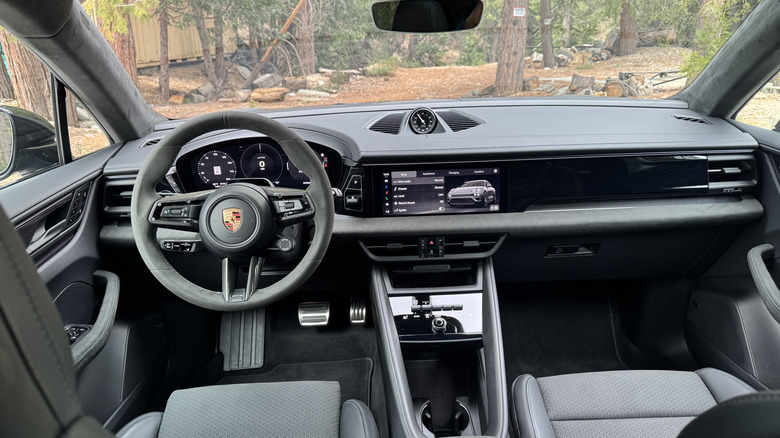 A wide shot of the Macan GTS' black and gray race-tex interior with trees visible through the windshield