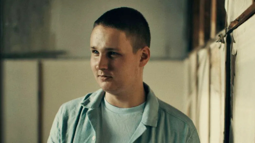 Denis, wearing a light blue shirt, speaks to the BBC in a warehouse