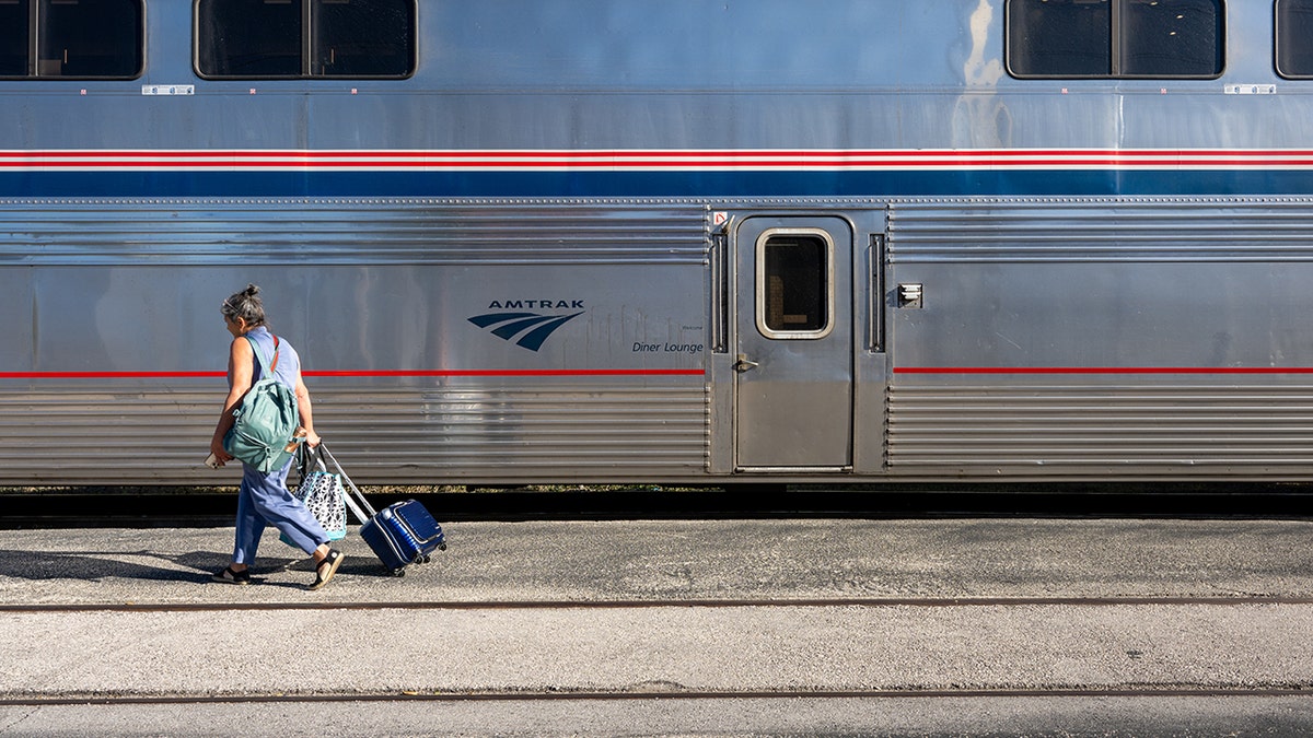 Woman with suitcase prepares to board an Amtrak train on November 12, 2025 in Austin, Texas.