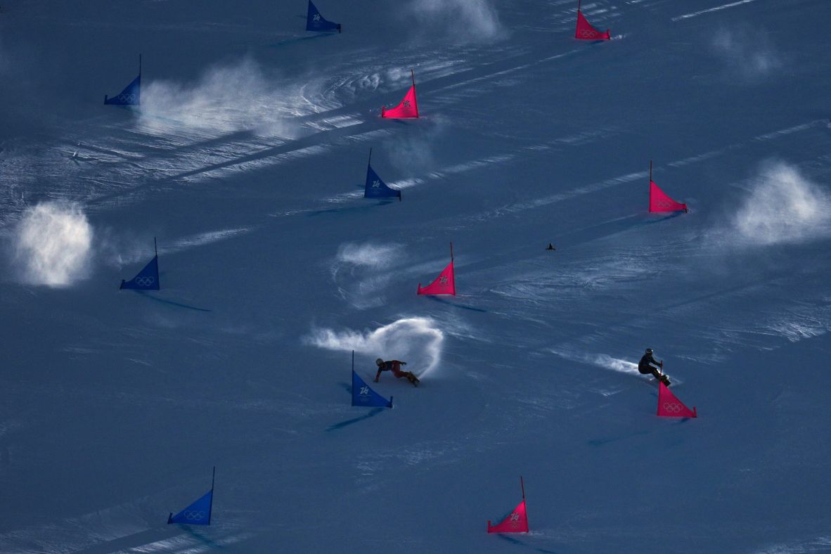 Switzerland's Ladina Caviezel, left, and Ukraine's Annamari Dancha race on snowboards during the parallel giant slalom event.