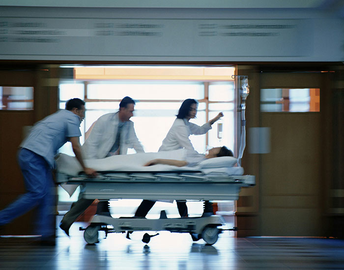 Medical team urgently pushing a patient on a hospital stretcher, a weirdly hilarious image capturing fast-paced healthcare action.