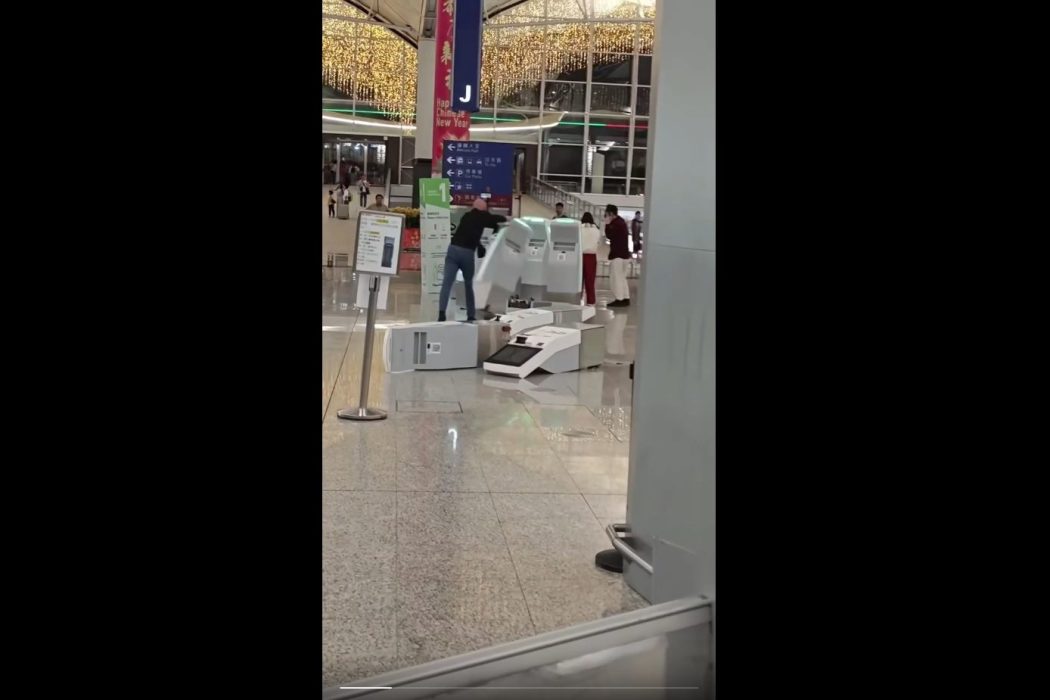 A screenshot of a video showing a man pushing over a self-service check-in kiosk at the Hong Kong International Airport on February 16, 2026. Photo: Screenshot, via Threads.