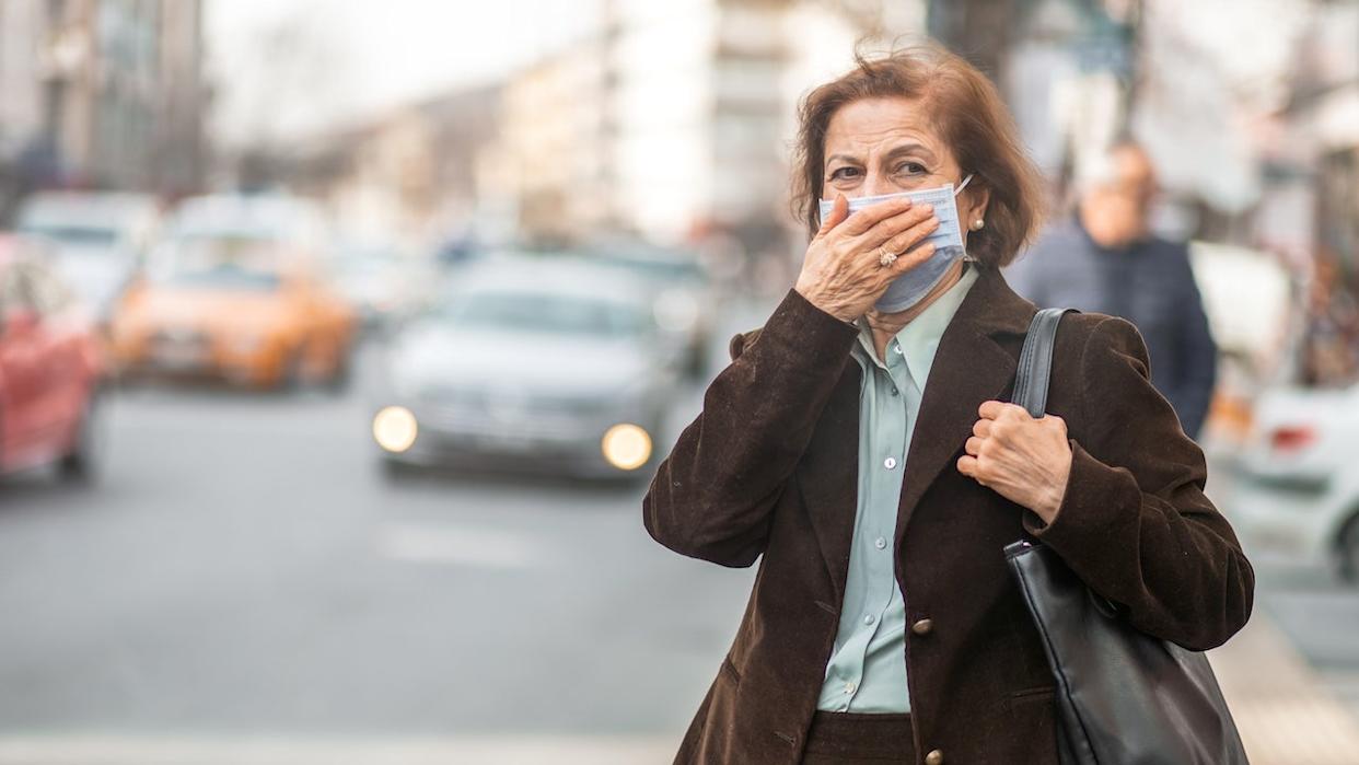 Woman on city street wearing mask