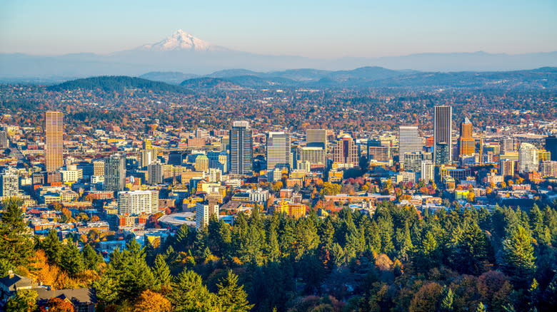 Skyline of Portland, Oregon and Mount Hood, the city framed by green trees shifting into autumn oranges