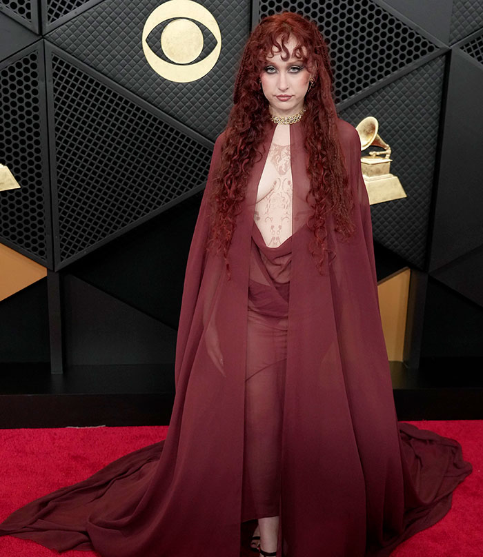 Chappell Roan in a sheer maroon gown and cape at the Grammys, breaking silence after her controversial look sparked outrage.