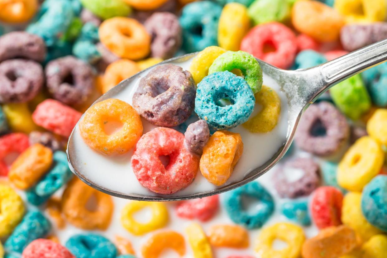 colorful breakfast cereal with milk on a spoon, close up with shallow depth of field
