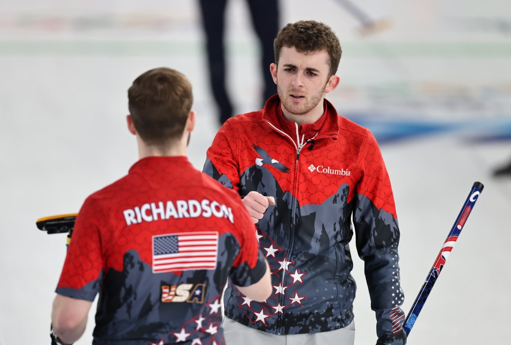 Daniel Casper of Team United States conversing with Ben Richardson during a curling match.