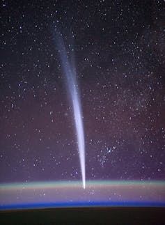 A bright vertical streak seen above the curve of Earth's horizon from space.