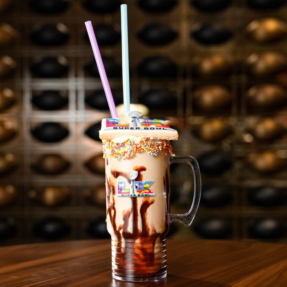 a decorated beverage in a large glass mug with colorful straws