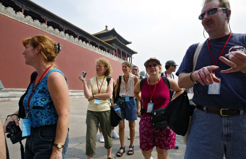 A group of American tourists from Minnesota wait for entry to the Forbidden City in Beijing, China, on 25 August 2003.