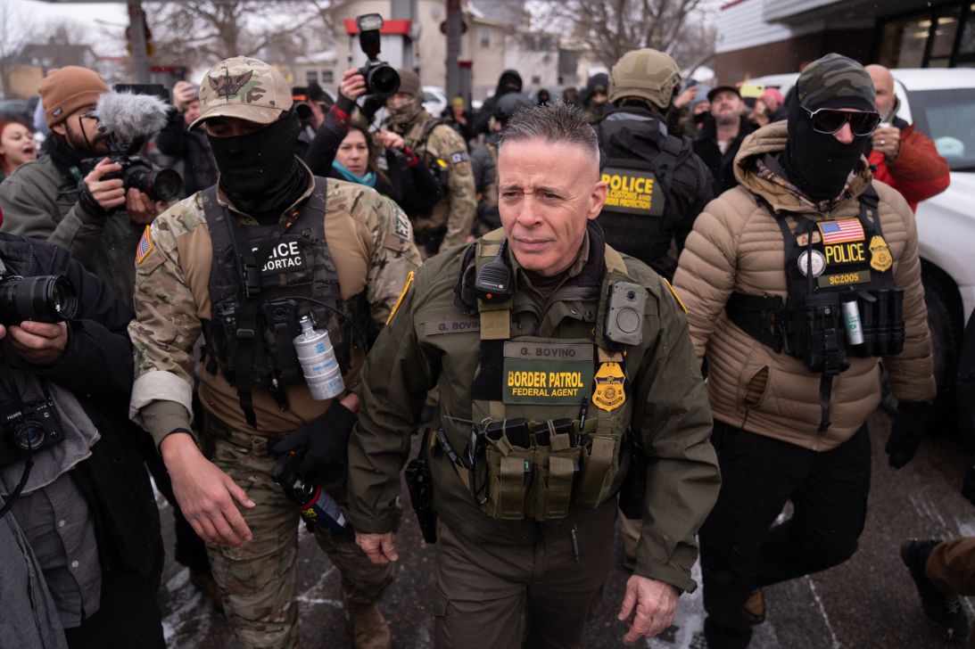 US Customs and Border Protection top official Gregory Bovino with his security team while a group of citizens opposed to the country's immigration policies protest against him in Minnesota on January 21, 2026.