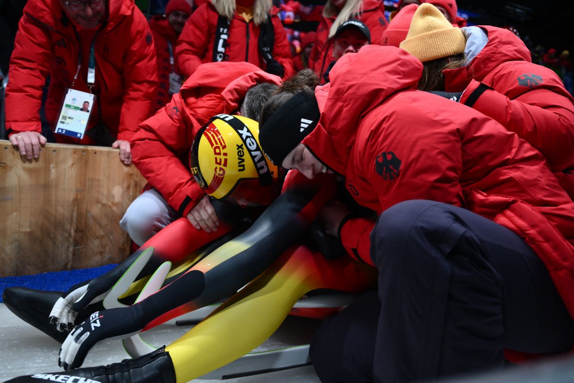 German luger Max Langenhan is swarmed by members of his team after clinching singles gold on his fourth and final run.