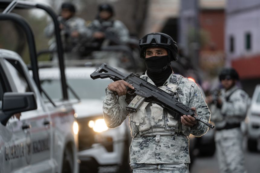 National Guard members and Mexican police stand guard at the Fiscalia General de la Republica in Mexico City, where the investigation into the death of drug lord 